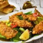 Air-fried frozen chicken tenders arranged on a plate with dipping sauce, golden and crispy