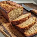 Sliced banana bread with moist texture on wooden board