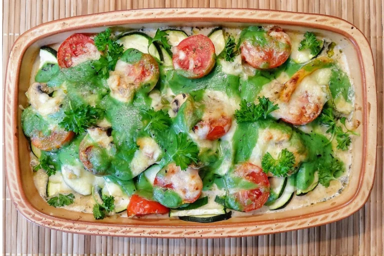 Baked dinner casserole with melted cheese, broccoli, and chicken in a glass baking dish