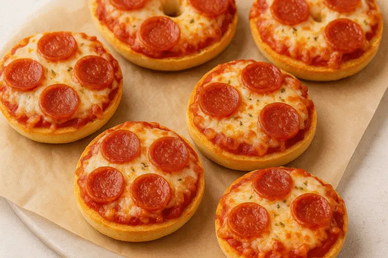 Golden pepperoni bagel bites on parchment paper, fresh from the oven.