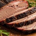 Perfectly sliced sous vide brisket on wooden board