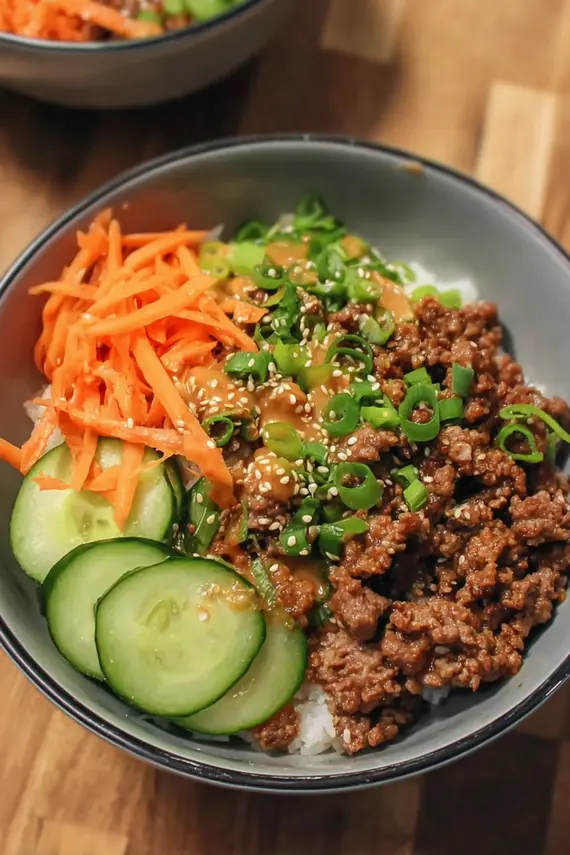 Delicious Korean Beef Bowl topped with vegetables and sesame seeds