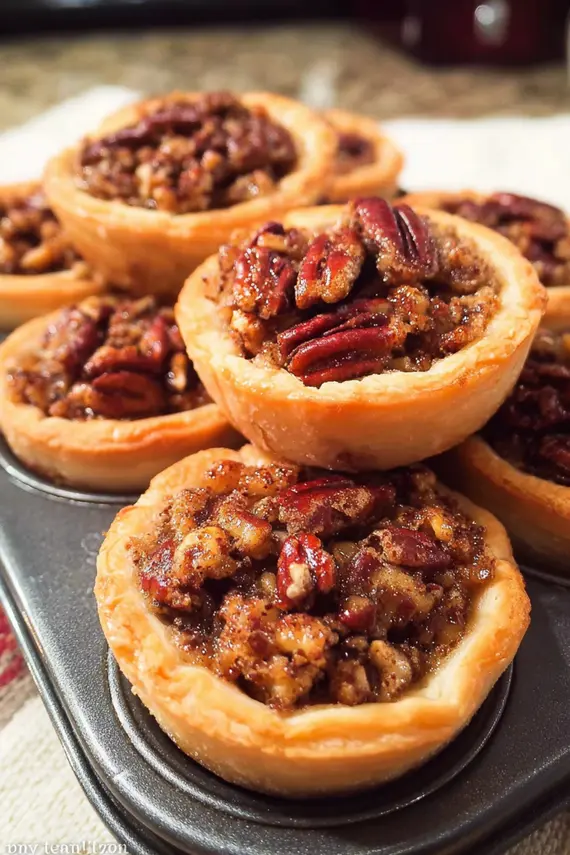 Freshly baked mini pecan pies showing the nutty caramel filling and golden crust