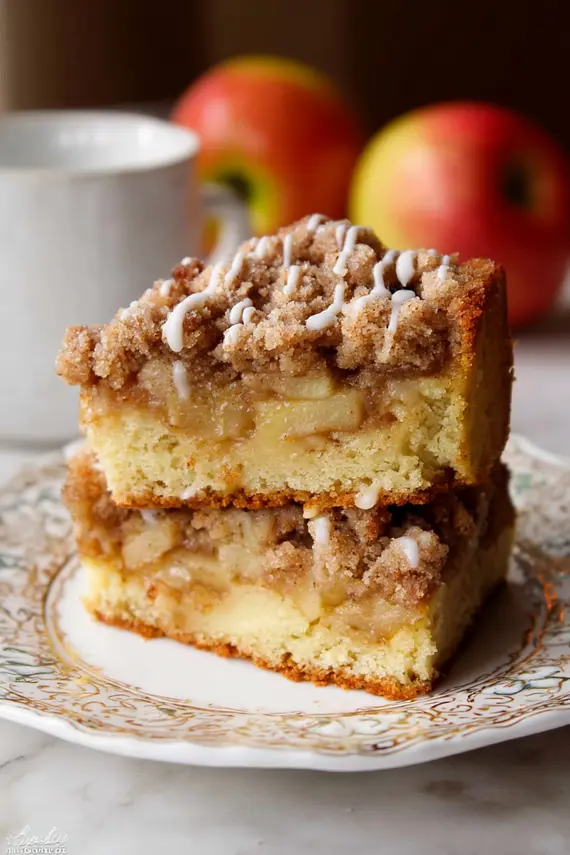 Slice of apple crumb cake served with vanilla ice cream and caramel drizzle