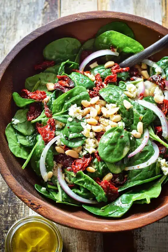 Sicilian spinach salad with citrus vinaigrette being prepared