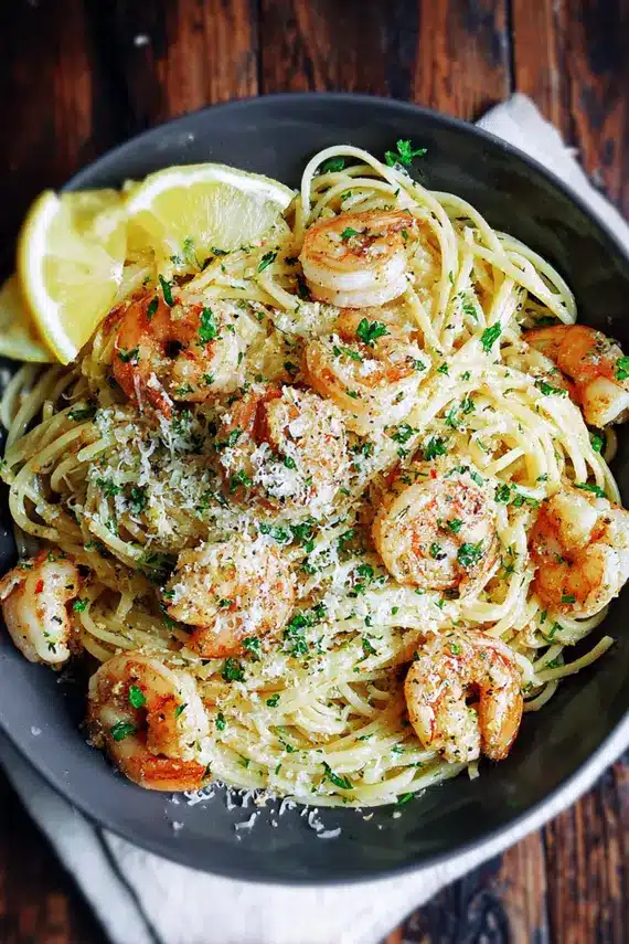 Close-up of garlic shrimp being cooked in a skillet with herbs