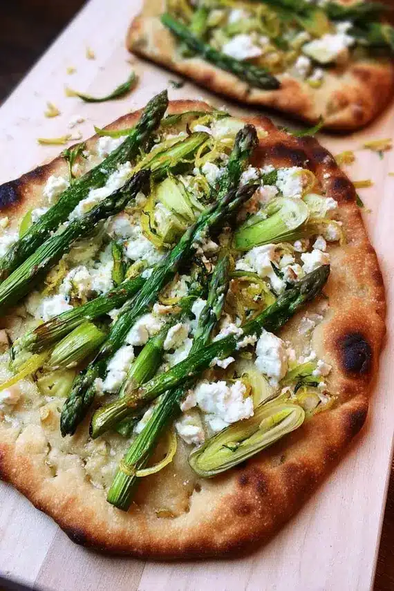 Freshly baked asparagus goat cheese flatbread with golden crust and melted cheese
