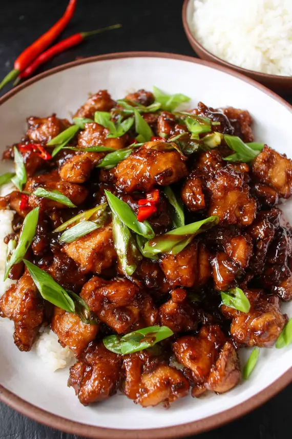Mongolian chicken in a skillet with glossy sauce