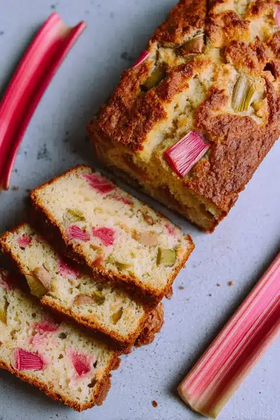 Freshly baked rhubarb bread showing pink rhubarb pieces throughout the loaf