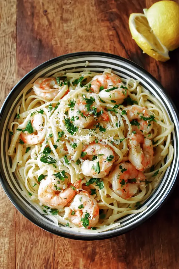 Finished garlic shrimp pasta in a white bowl with a fork twirling pasta