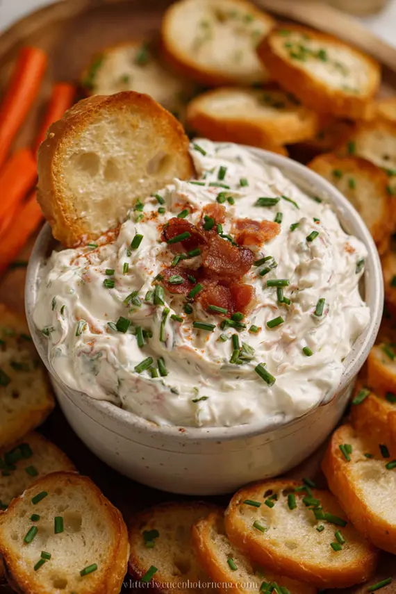 Spicy cream cheese dip with red pepper flakes in a decorative bowl surrounded by tortilla chips