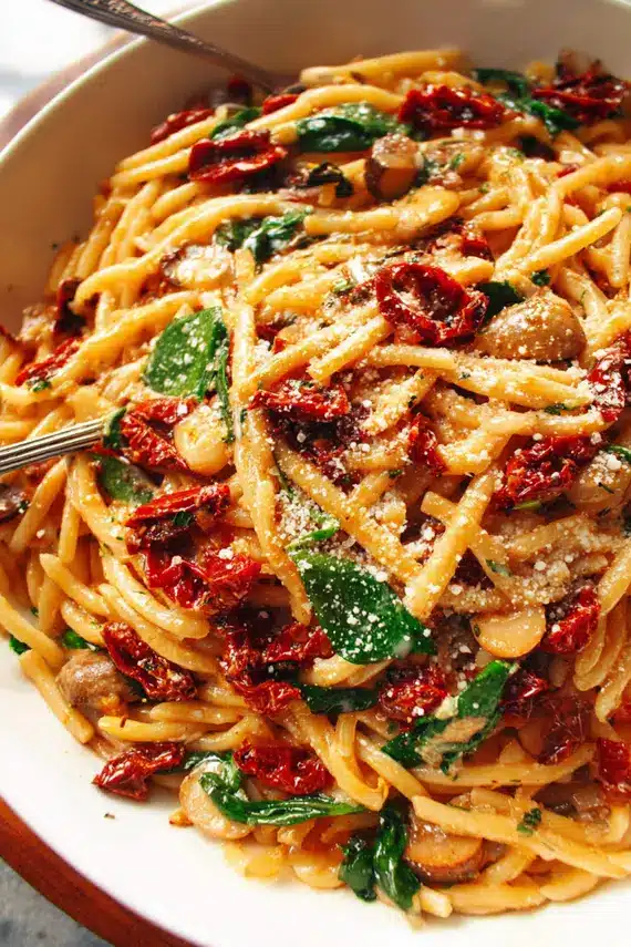 Sun Dried Tomato Pasta with fresh basil and Parmesan cheese in a skillet