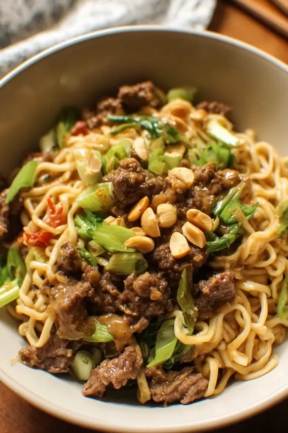 Bowl of delicious Beef Peanut Noodles with colorful vegetables and garnish