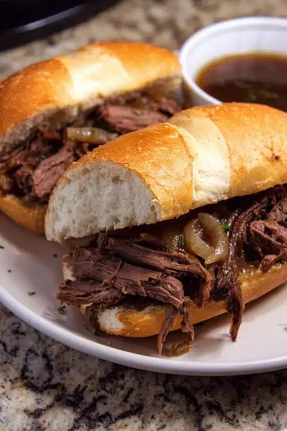 Close-up of beef au jus sandwich with melted cheese on crusty bread