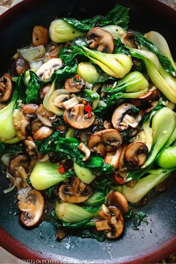 Garlic Mushroom Bok Choy Stir Fry in a wok with steam rising, showing vibrant green vegetables and golden mushrooms