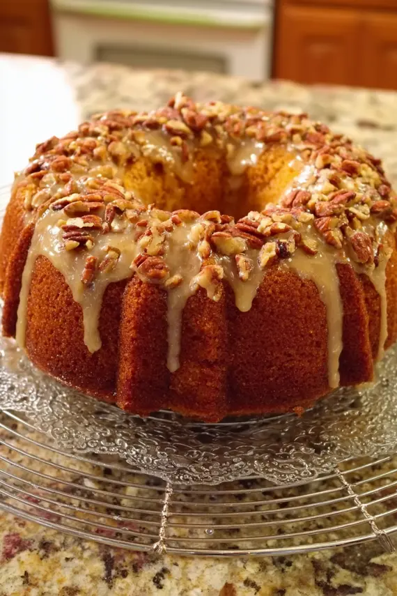 Freshly baked pecan apple bundt cake with glaze dripping down the sides