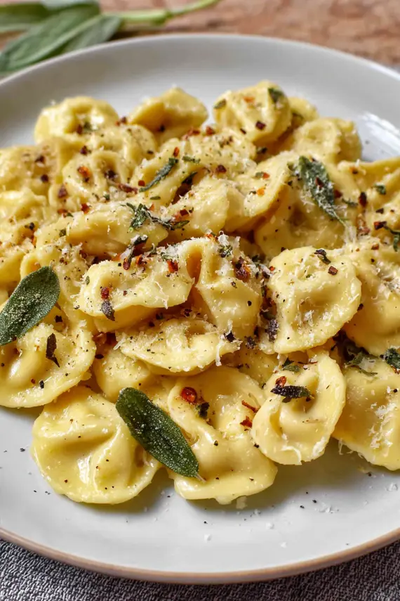 Close-up of butter sauce drizzled over parmesan tortelli pasta