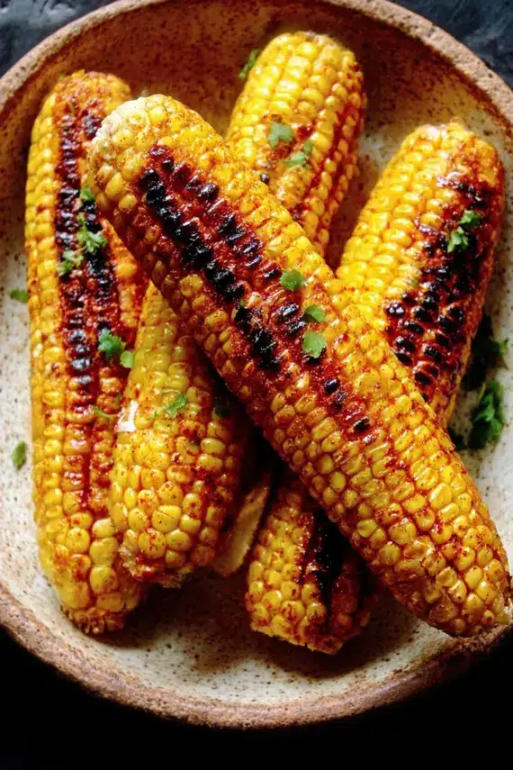 Charred corn side dish served on a platter with garnishes