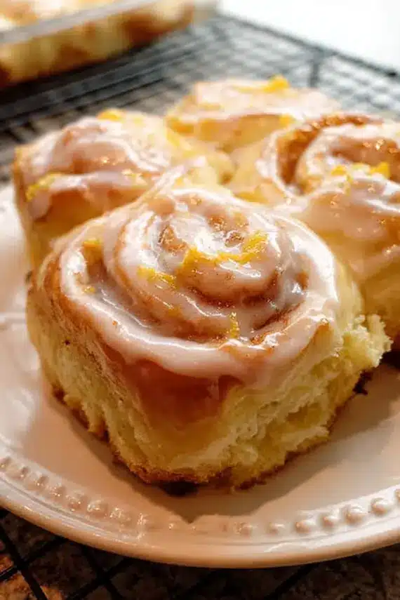 Sweet zesty orange rolls served on a plate with fresh orange slices and berries