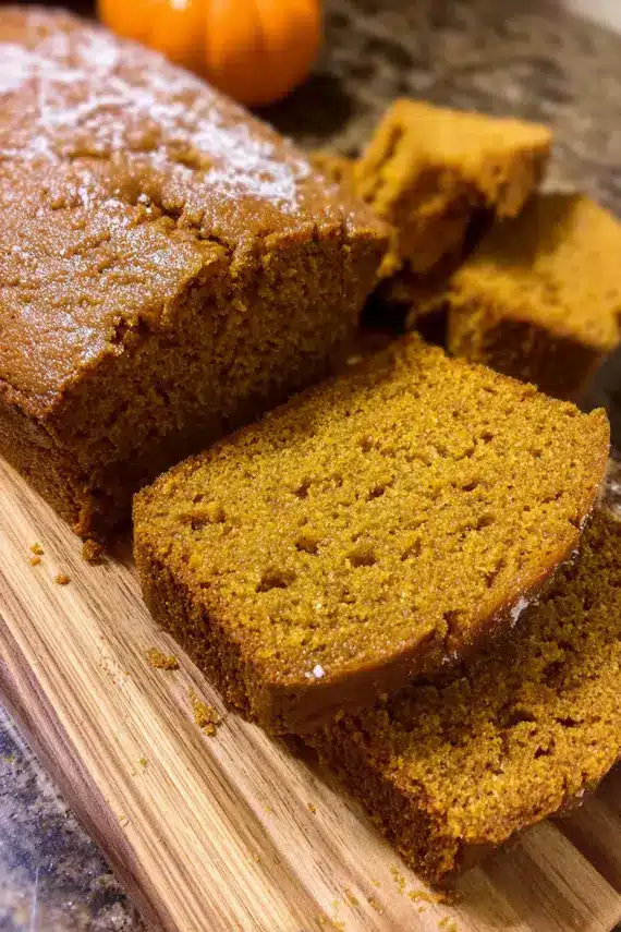 Slice of pumpkin bread with cream cheese spread and coffee