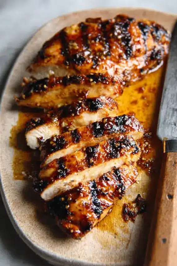 Perfectly grilled Asian ginger marinade chicken with visible grill marks and garnished with green onions and sesame seeds