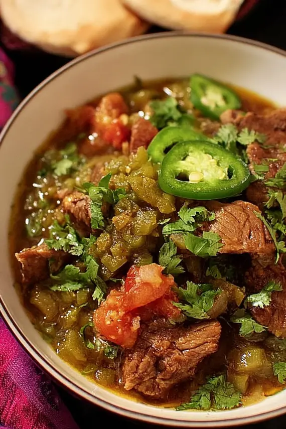 Mexican Green Chile Beef Stew in a bowl with toppings