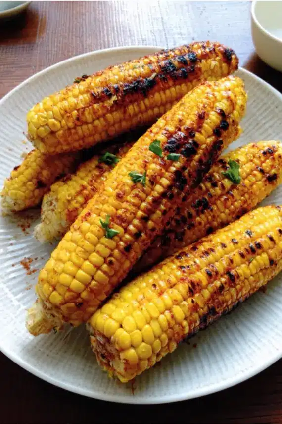 Perfectly grilled corn with char marks and seasoning