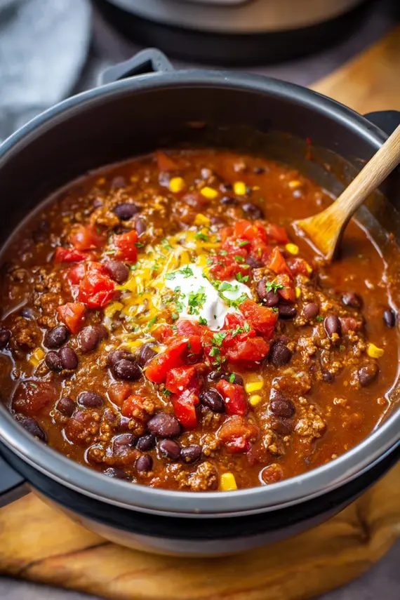 Ground beef taco chili served over rice with cheese and avocado garnish