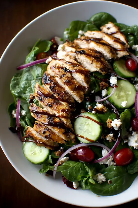 Healthy grilled chicken salad with fresh vegetables and homemade balsamic dressing served in a bowl