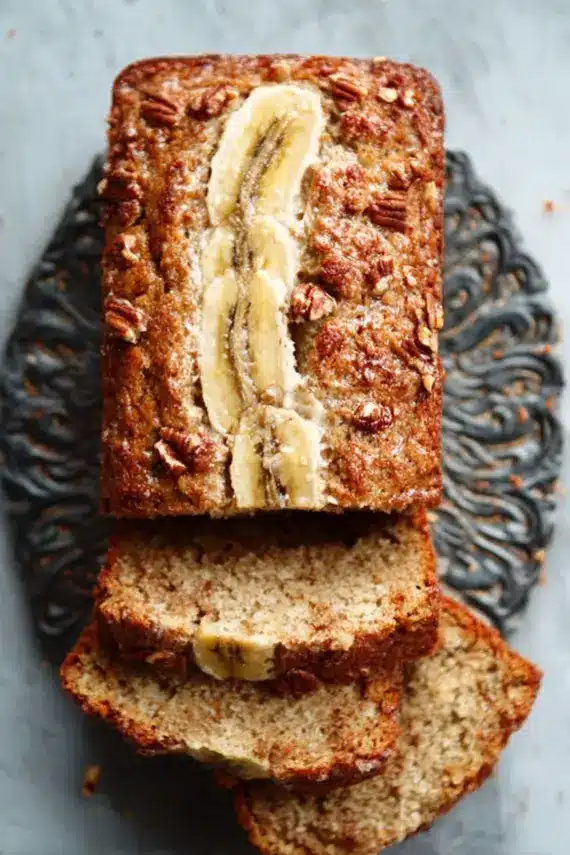 Sliced hummingbird cake banana bread with cream cheese glaze showing pineapple and banana texture