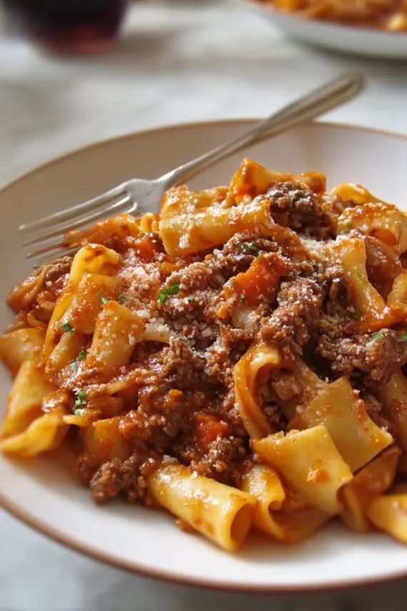 Italian Beef Ragu Pasta served in a bowl with fresh herbs and parmesan cheese