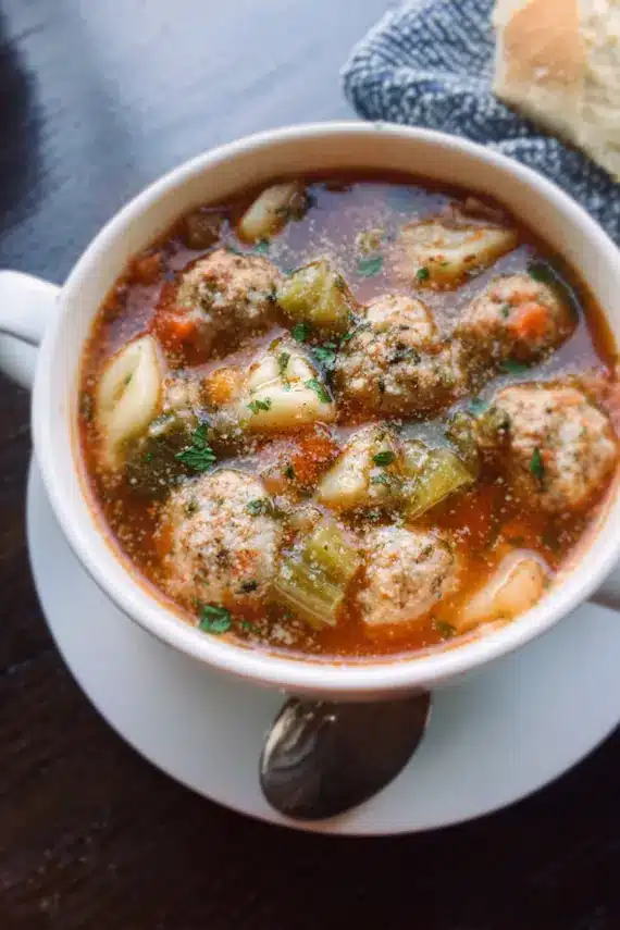 Steaming bowl of parmesan meatball soup with tender meatballs and vegetables in a savory broth