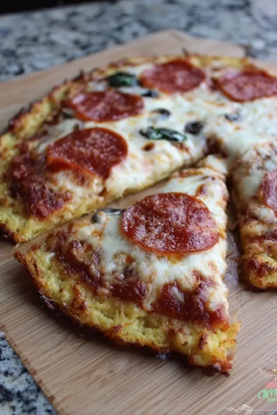 Keto-friendly spaghetti squash pizza crust with various toppings on a wooden serving board