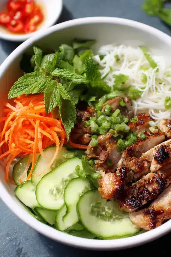 Lemongrass Chicken Spring Roll Bowls with vibrant vegetables and herbs arranged beautifully in a bowl