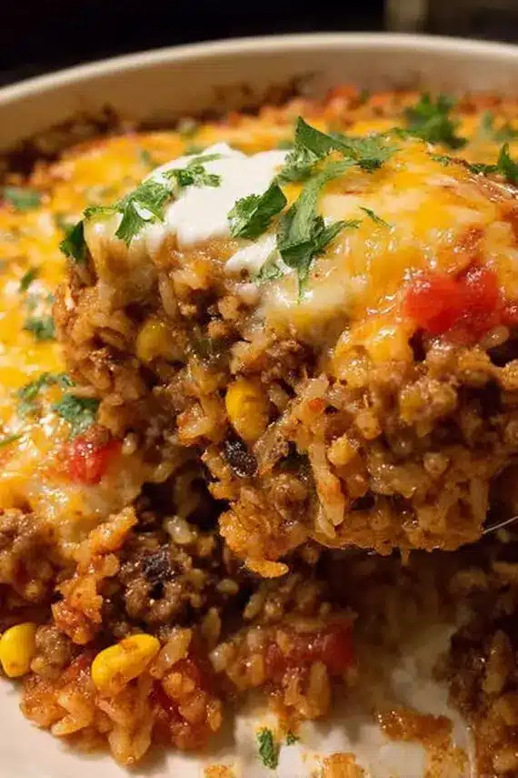 Mexican ground beef casserole with melted cheese and garnishes