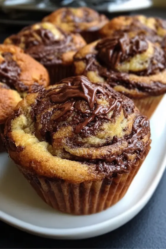 Close-up of nutella swirled banana muffins showing the beautiful marbled pattern of chocolate hazelnut spread through the moist banana muffin