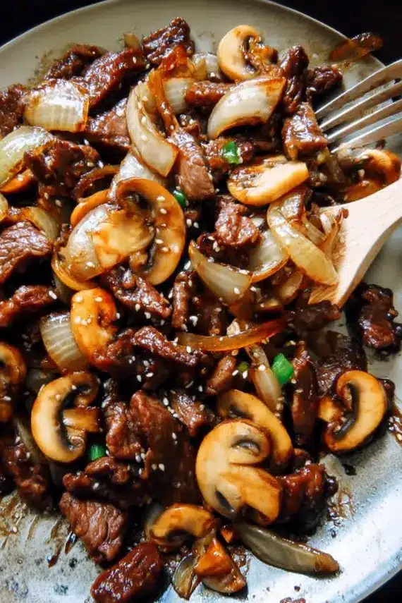 Beef Onion Mushroom Stir Fry served over rice with garnishes