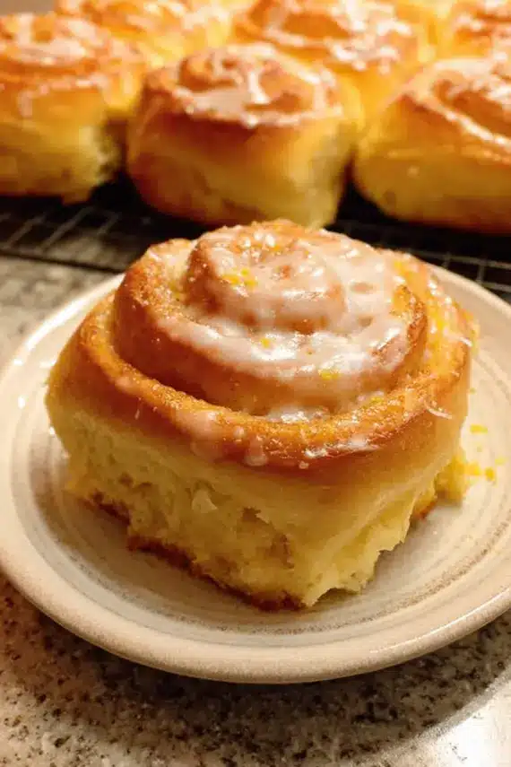 Freshly baked sweet zesty orange rolls with orange glaze drizzled on top