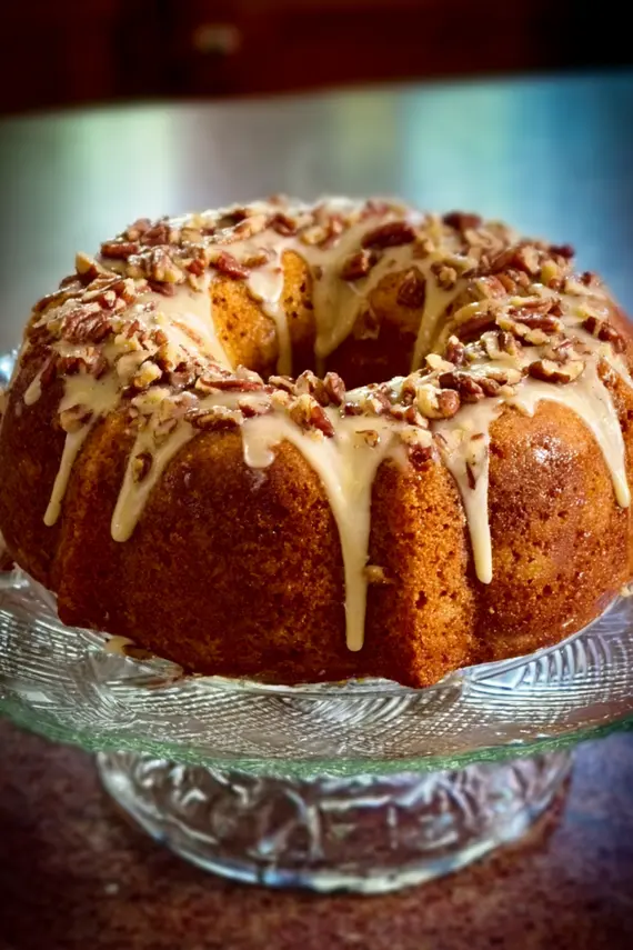 Pecan apple bundt cake sliced and served with a scoop of vanilla ice cream