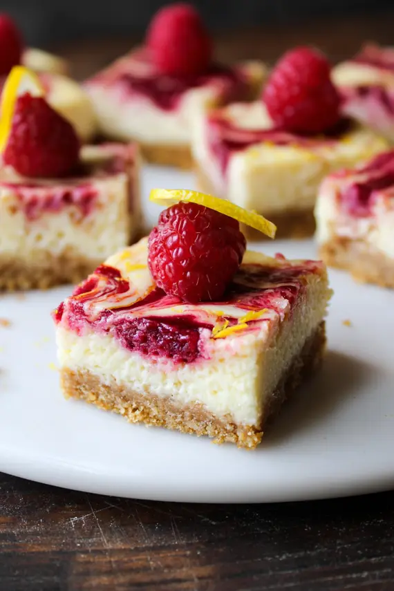 Swirled Raspberry Lemon Cheesecake Bars with beautiful raspberry swirls throughout creamy cheesecake on a graham cracker crust
