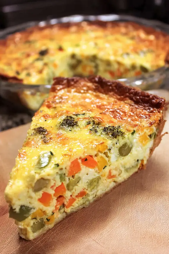 Mixed vegetable quiche served on a brunch table with sides and garnishes