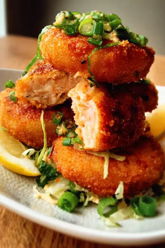 Golden brown crispy shrimp patties with a side of lemon wedges and dipping sauce