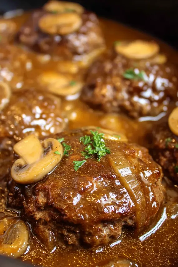 Slow Cooker Salisbury Steak served over mashed potatoes with green vegetables on the side