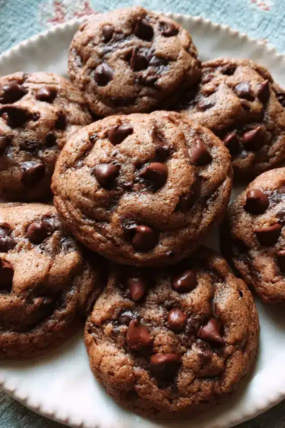 Freshly baked chocolate chip chocolate cookies cooling on a wire rack