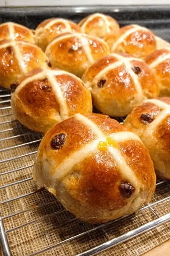 Hot cross buns served on a brunch table with butter, honey and tea