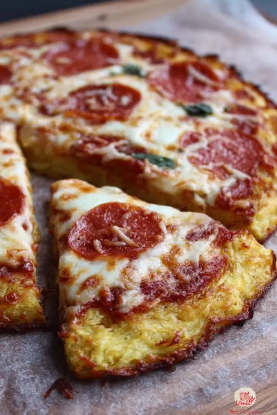 Freshly baked keto pizza with spaghetti squash crust topped with pepperoni and olives