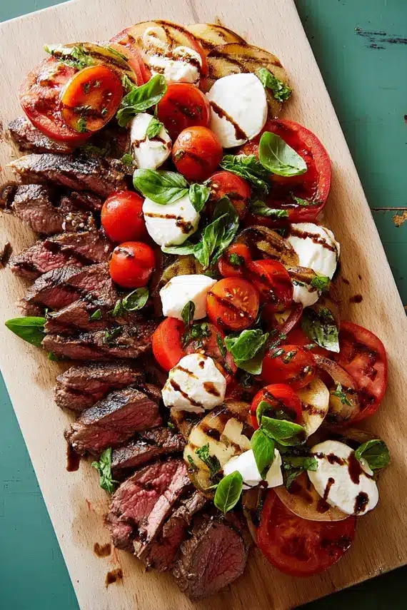 Beautifully arranged Steak Caprese Salad with sliced ribeye, fresh mozzarella, and ripe tomatoes