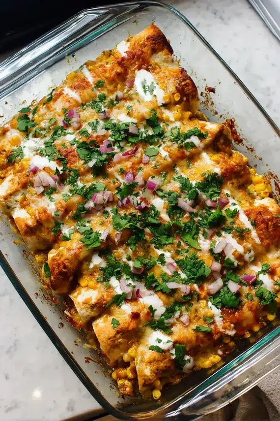 Freshly baked sweet potato enchiladas with melted cheese and garnishes