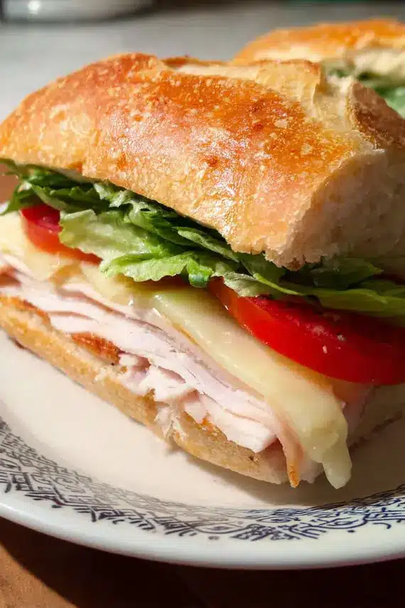 Turkey Brie Ciabatta Sandwich with layers of turkey, brie, and fresh vegetables on toasted ciabatta bread