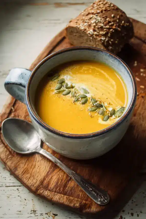 Creamy plant based vegan butternut squash soup in a bowl with garnishes